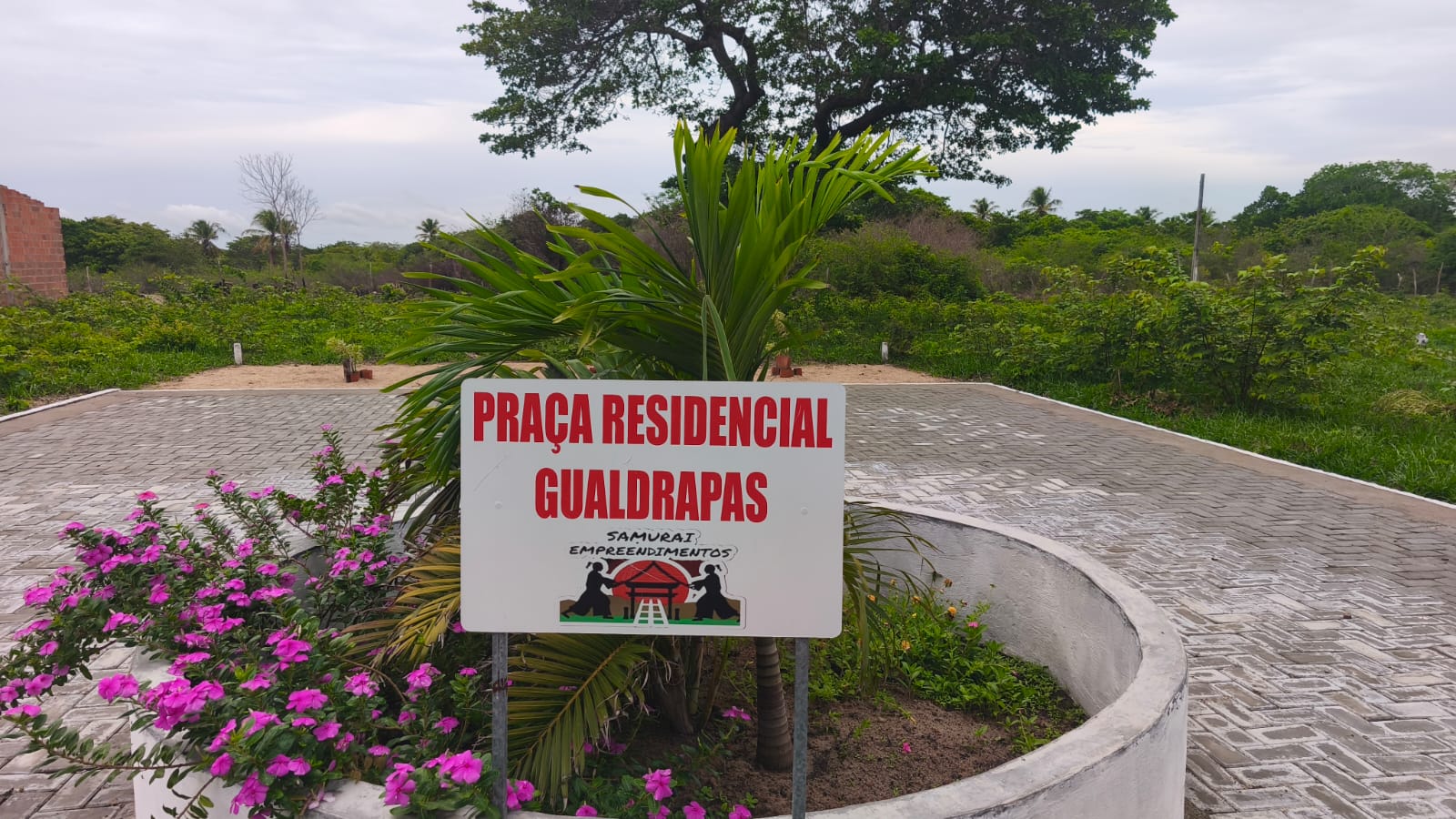 Placa do Residencial Gualdrapas com flores e paisagismo